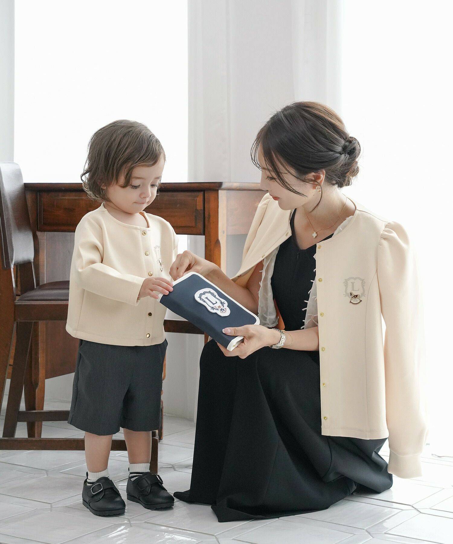 カーディガンレディースダンボールニットトップスクルーネックゴールドボタン木馬刺繍エンブレム刺繍フレアラインパネルライン袖口カフスパフスリーブスラッシュポケット羽織りトップス肩掛けリンク親子コーデ